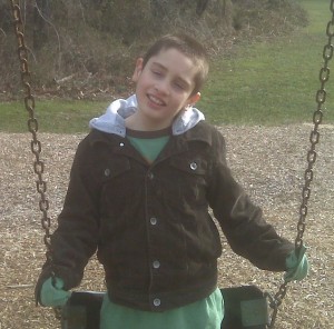 young boy with autism playing on a swing
