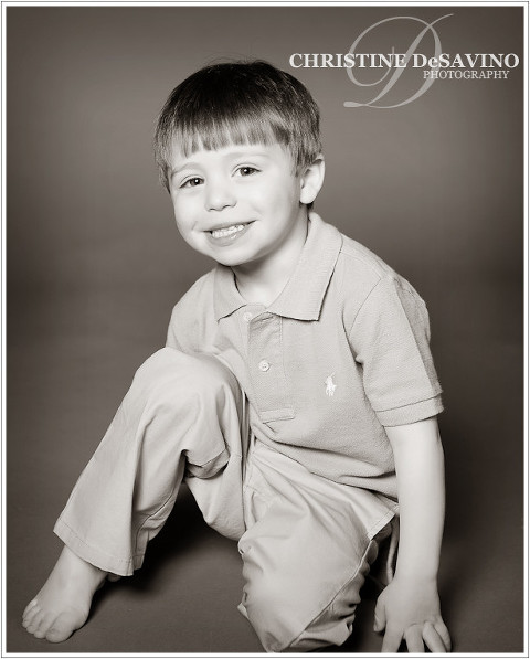Black and white studio portrait of an adorable little boy