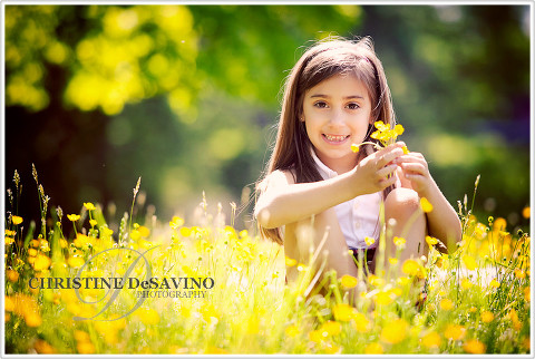 Beautiful girl holding buttercups in a field