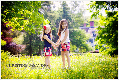 Two beautiful sisters holding hands in the sunshine with Ringwood Manor in background