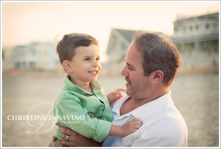 A father holds his young son on the beach at sunset, LBI NJ