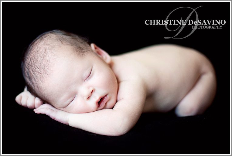 Newborn baby boy sleeping on a black background