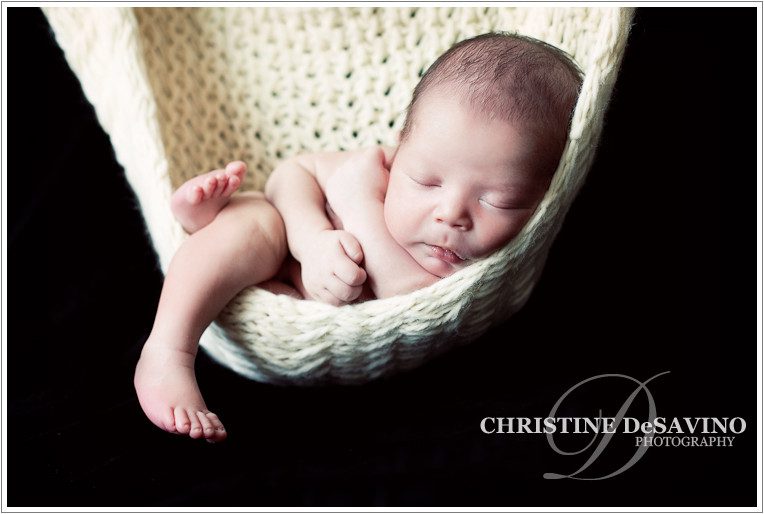 Peaceful newborn boy sleeping in a hammock