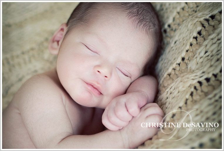 Photo of a sweet newborn baby boy sleeping on a blanket