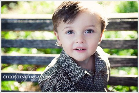 Close up of adorable boy on park bench with sunlit hair