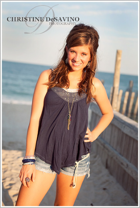 Teenage girl stands on boardwalk by the ocean on Long Beach Island