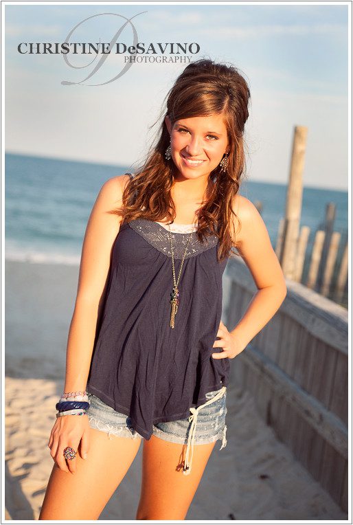 Teenage girl stands on boardwalk by the ocean on Long Beach Island