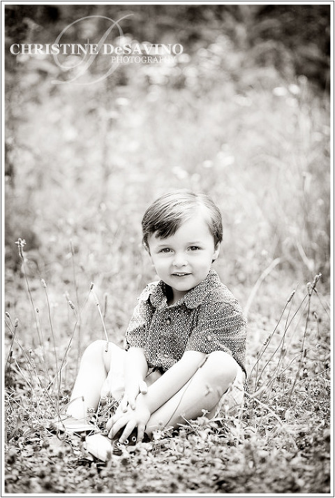Black and white image of beautiful boy sitting in a field, Wyckoff NJ