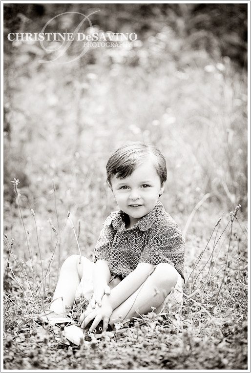 Black and white image of beautiful boy sitting in a field, Wyckoff NJ