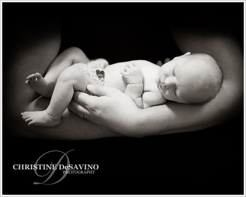 newborn boy being held in his father's arms - NJ Newborn Photographer