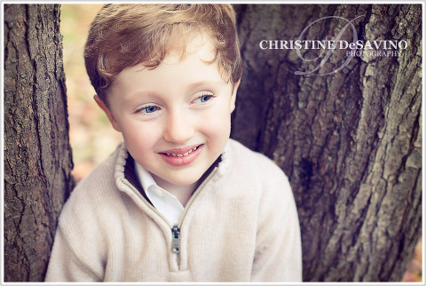 Boy smiling by a tree - NY Children's Photographer