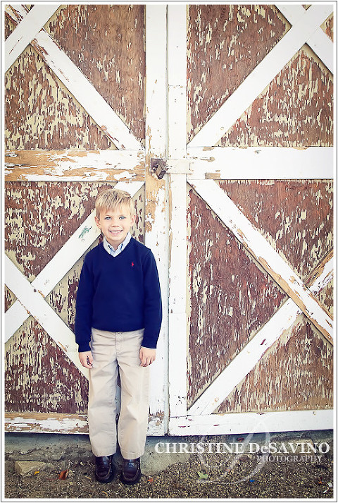 Boy leaning against barn doors - NJ Children's Photographer