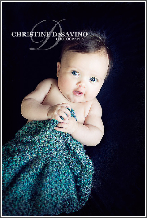 Beautiful blue-eyed baby on black with green knit - NY Baby Photographer
