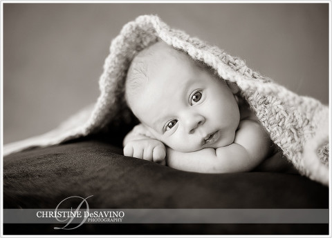 Black and white of baby awake under a blanket - NY Baby Photographer