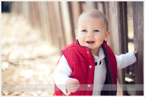 Boy in red vest holding fence - NJ Child Photographer