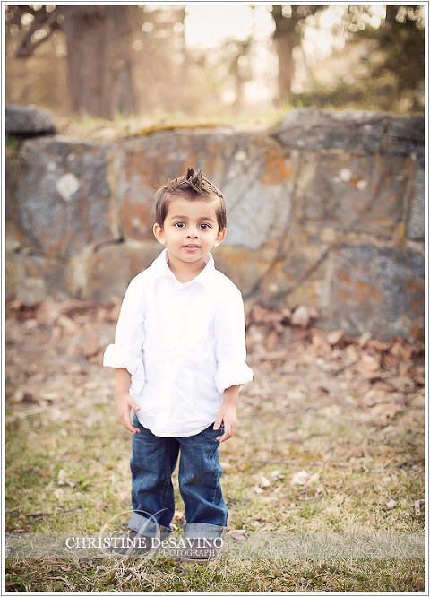 Adorable boy stands by stone wall - NY Child Photographer