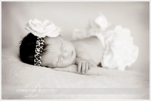 Black and white of sleeping newborn girl with leopard skin bow - NJ Newborn Photographer