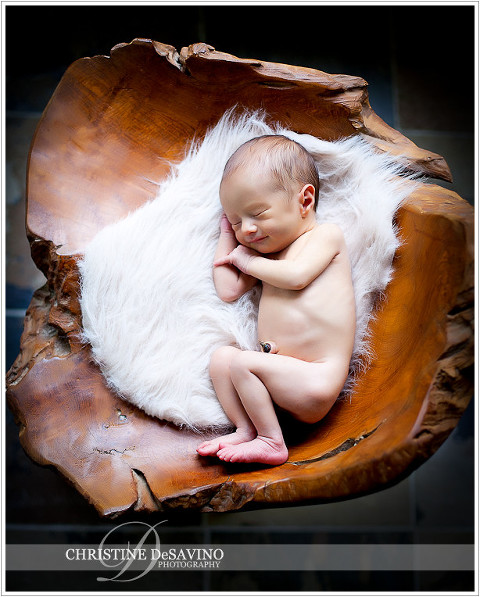 Newborn smiles on fur and wooden chair - NJ Newborn Photographer