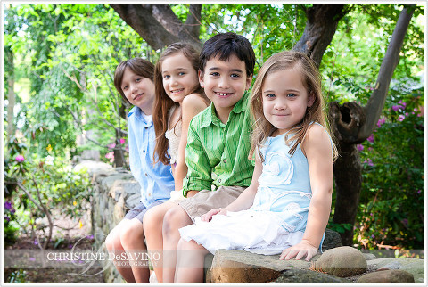Family of four sits on stone wall - NJ Family Photographer