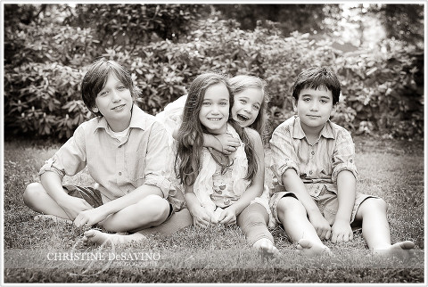 Black and white of four siblings on grass - NJ Family Photographer