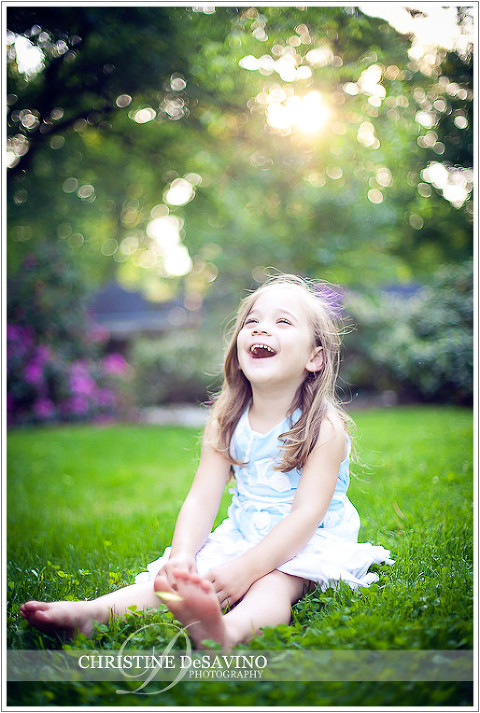 Girl on lawn laughing - NJ Child Photographer