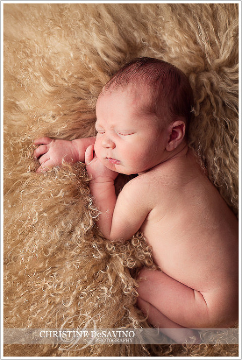 Newborn boy sleeps on furry pillow - NJ Baby Photographer